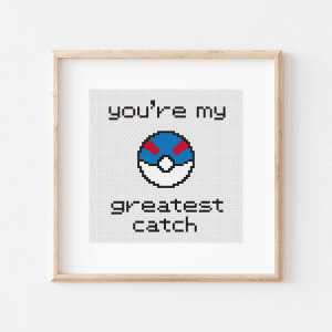 Cross stitch that has words in the font from the early Pokemon games. At the top, it says "you're my," followed by art of a Great Ball, followed by the text "greatest catch"